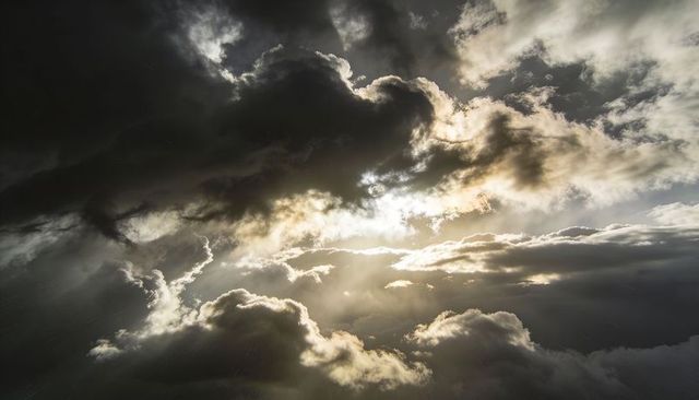 Sunbeams Piercing Dark Storm Clouds Casting Dramatic Crepuscular Rays Through Gaps