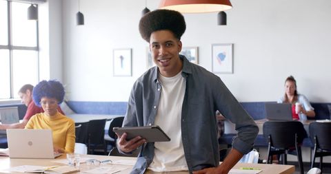 Confident Businessman Holding Tablet in Modern Office