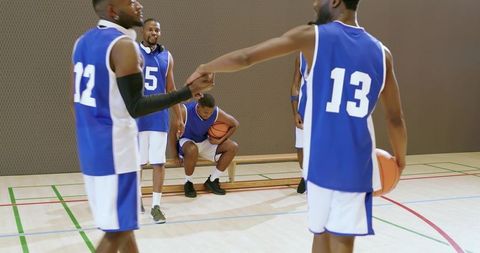 African american basketball teammates gathering on gym court showing camaraderie and focus