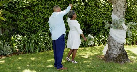 Senior Couple Dancing Joyfully at Garden Wedding