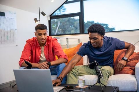Young male friends collaborating on podcast startup at home