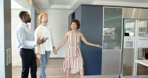 Real estate agent showing modern home to multiracial couple