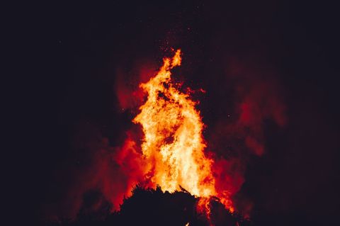 Dramatic Bonfire Flames Rising Into Dark Night Sky Bright Orange Fire and Sparks
