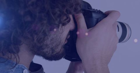 Young photographer taking pictures with professional camera