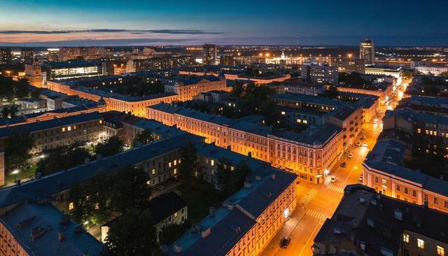 Aerial night skyline showing historic blocks glowing along diagonal streets at twilight