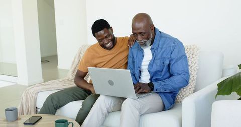 Father and Son Bonding Over Laptop in Modern Living Room
