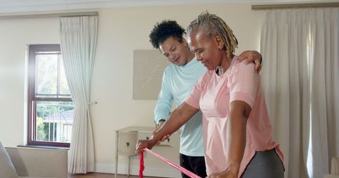 Senior Woman Exercising with Resistance Band in Living Room for Wellness