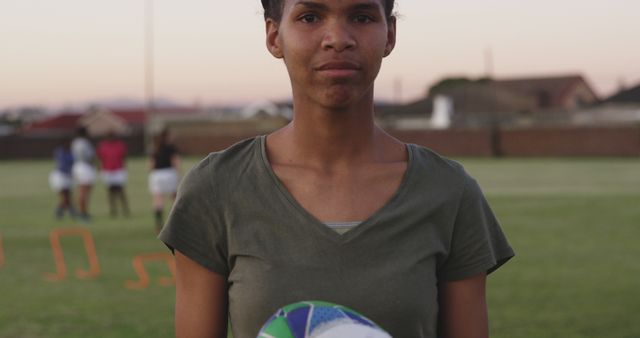 Determined Female Rugby Player Holding Ball on Field - Download Free Stock Images Pikwizard.com