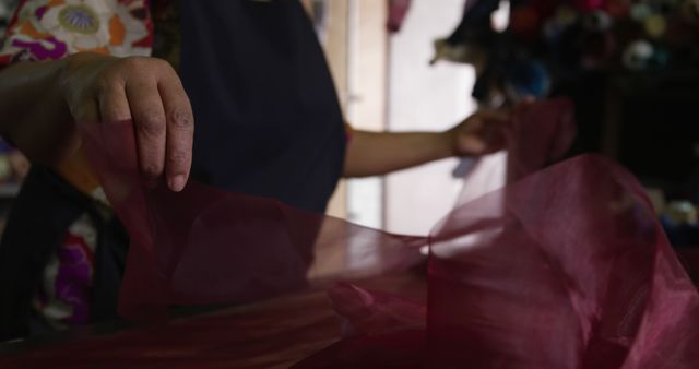 Close-up of tailor's hands working with red fabric in workshop - Download Free Stock Images Pikwizard.com