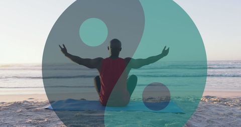 Senior Man Meditating with Yin Yang Symbol on Beach at Sunset