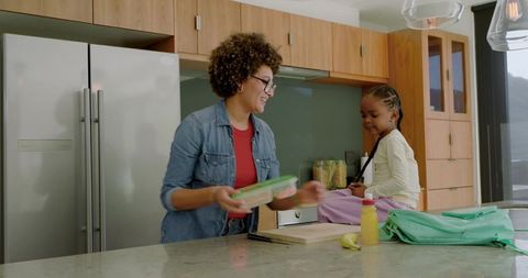 Mother preparing lunch for daughter in modern kitchen