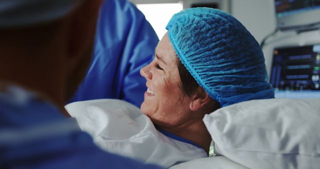Nurse interacting with a smiling patient in a hospital room, providing comfort and care. Ideal for healthcare websites, medical blogs, hospital brochures, and wellness articles to depict compassionate care and patient recovery.