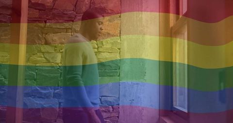 Man reflecting in rustic stone-faced hallway with rainbow overlay