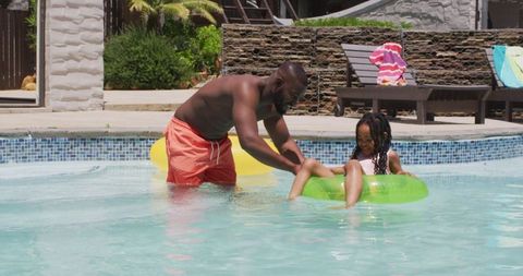 Father and daughter enjoying summer together in pool