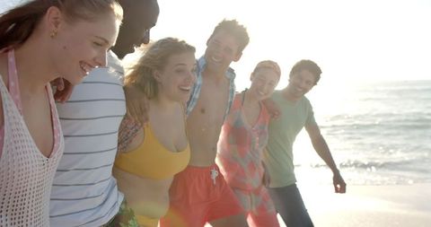 Joyful Friends Enjoying Sunny Beach Walk with Laughter