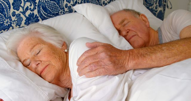Caucasian senior couple sleeping on bed in bedroom at comfortable home. Senior man touching senior woman on bed 4k