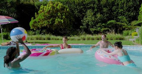 Friends Enjoying Summer Playtime in Backyard Pool with Inflatable Toys