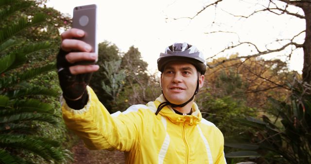 An active man in cycling gear enjoys a selfie moment amidst nature. - Download Free Stock Photos Pikwizard.com
