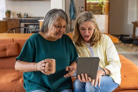 Mature Women Enjoying Tablet Coffee Chat at Home