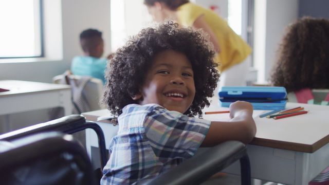 Boy with disability smiling while being in classroom, creating a positive and inclusive learning environment. Classroom scene depicts diversity and joy among students, emphasizing educational inclusion and support. Ideal for educational materials, inclusivity projects, and campaigns promoting diversity.