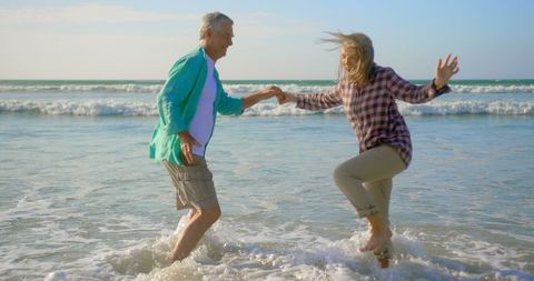 Joyful Senior Couple Dancing at Sunset Beach