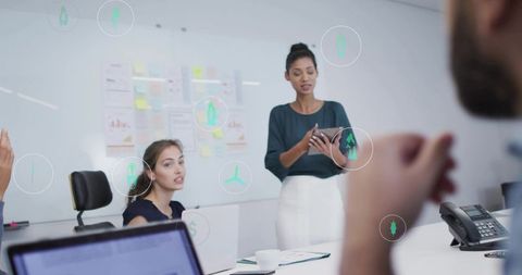 Woman presenter leading meeting with tablet and AR data overlays for business collaboration