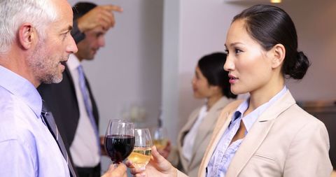 Business professionals networking in bar with wine