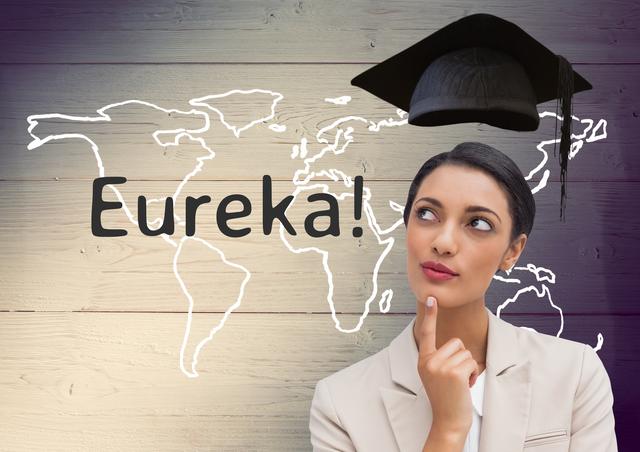 Businesswoman in professional attire thinking with a mortarboard above her head and 'Eureka!' text in front of a wooden background with a world map. Ideal for concepts related to education, success, global business, inspiration, and career achievements.