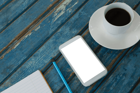 transparent smartphone, coffee cup, notepad on rustic blue table - Download Free Stock Videos Pikwizard.com