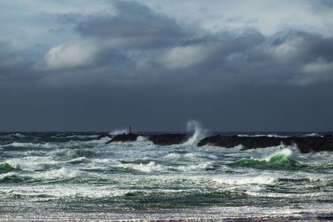 Dramatic Sea with Crashing Waves Against Pier