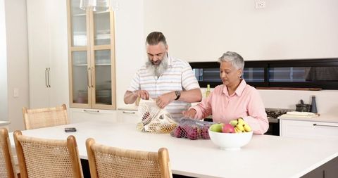 Senior Couple Unpacking Groceries in Modern Minimalist Kitchen