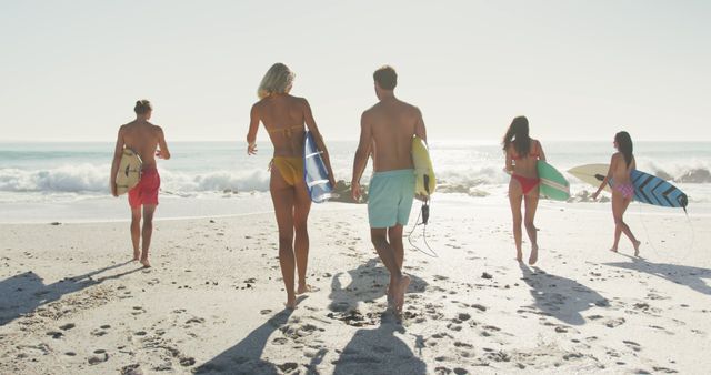 Group of Friends Walking Toward Ocean with Surfboards on Sunny Beach Day - Download Free Stock Images Pikwizard.com