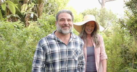 Senior Couple Strolling Garden Path in Dappled Sunlight