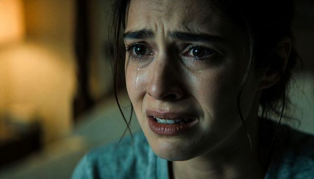 Close-up crying woman at bedside expressing raw emotion and tears
