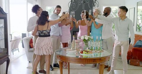 Friends Toasting with Champagne in Bright Living Room Party Gathering