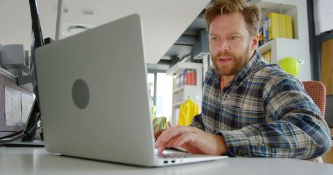 Focused Man Working on Laptop in Office Environment - Download Free Stock Images Pikwizard.com