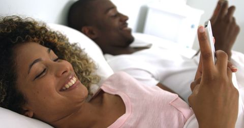Joyful Couple in Bed Celebrating Engagement with Ring