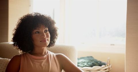 Peaceful Woman Relaxing in Natural Sunlight at Home