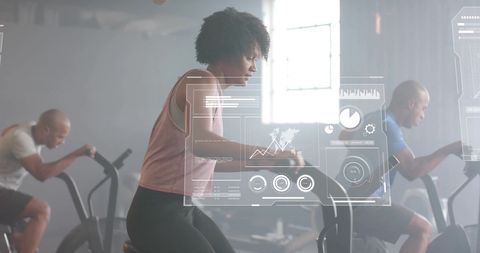 Diverse fitness enthusiasts cycling with digital data interface