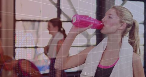 Fit Woman Hydrating After Workout in Gym Environment