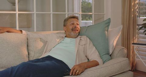 Senior Man Relaxing Joyfully on Comfortable Home Sofa