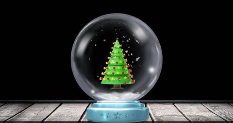 Festive christmas tree in decorative snow globe on wooden tabletop