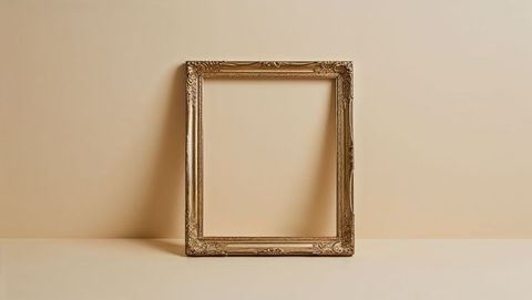 Ornate gold picture frame on beige background casting shadow