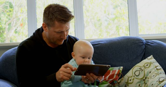 Father and Baby Bonding While Watching Tablet on Couch at Home - Download Free Stock Images Pikwizard.com