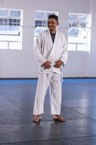 African American Man in White Gi Training in Dojo