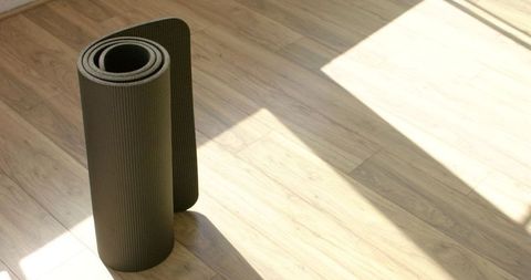 Rolled Yoga Mat on Sunlit Wooden Floor - Download Free Stock Images Pikwizard.com