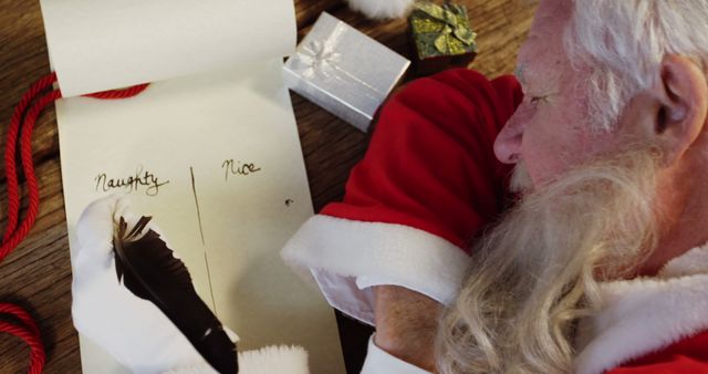 Santa Claus Writing Naughty and Nice List with Feather Quill - Download Free Stock Images Pikwizard.com