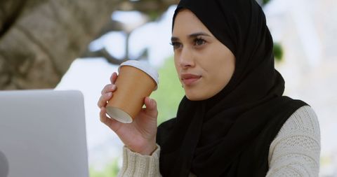 Young Woman in Hijab Enjoys Coffee Laptop Affairs Outdoors