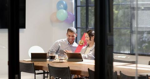 Colleagues Celebrating with Gift in Bright Office Space