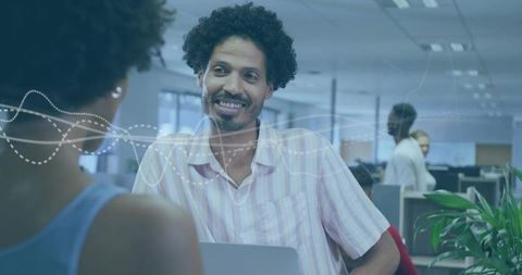 Smiling man engaging in friendly conversation at modern office